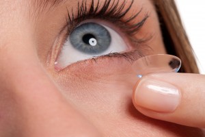 Close-up of blue woman eye with contact lens applying, macro lens